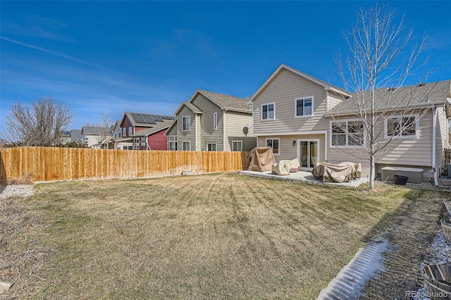 back of property featuring a patio, roof with shingles, a yard, and fence