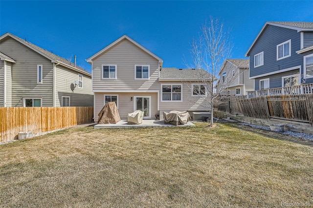 rear view of property featuring a lawn, a fenced backyard, and a patio area