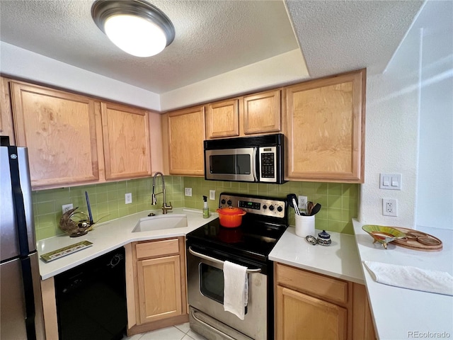 kitchen with decorative backsplash, sink, stainless steel appliances, and a textured ceiling