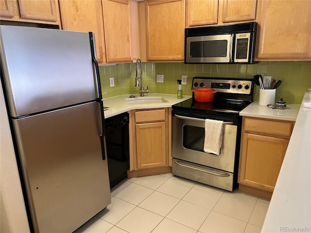 kitchen featuring appliances with stainless steel finishes, decorative backsplash, sink, and light tile patterned flooring