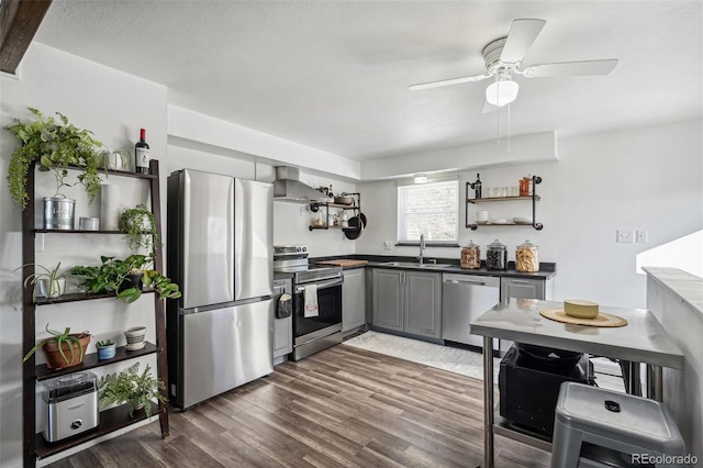 kitchen with sink, gray cabinets, stainless steel appliances, dark hardwood / wood-style floors, and wall chimney exhaust hood