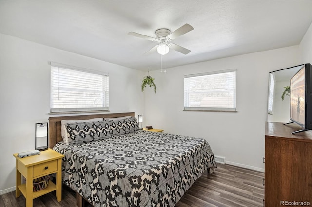 bedroom with multiple windows, dark wood-type flooring, and ceiling fan