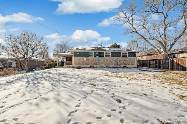 view of snow covered back of property