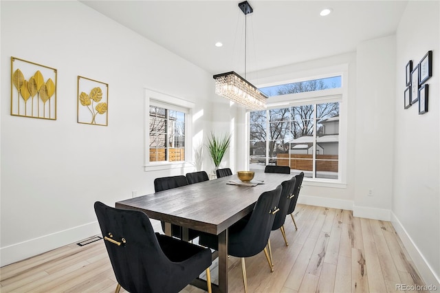 dining area featuring light wood-type flooring and an inviting chandelier