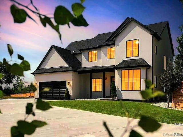 view of front of house with a garage, driveway, a lawn, and stucco siding