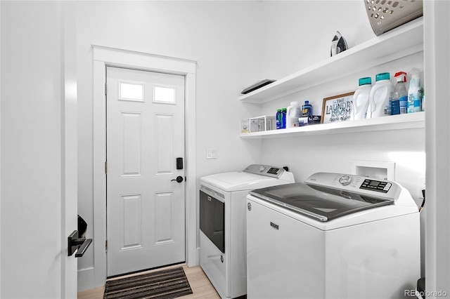 laundry room with light wood-style floors, washing machine and dryer, and laundry area