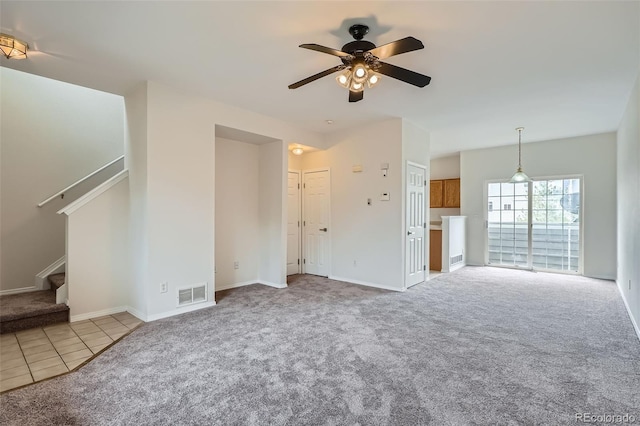 unfurnished living room with carpet floors, ceiling fan, stairs, and baseboards