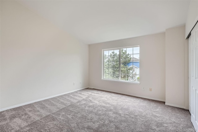 carpeted spare room featuring baseboards