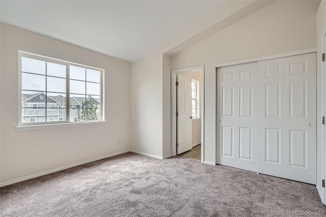 unfurnished bedroom with multiple windows, carpet, baseboards, and a closet