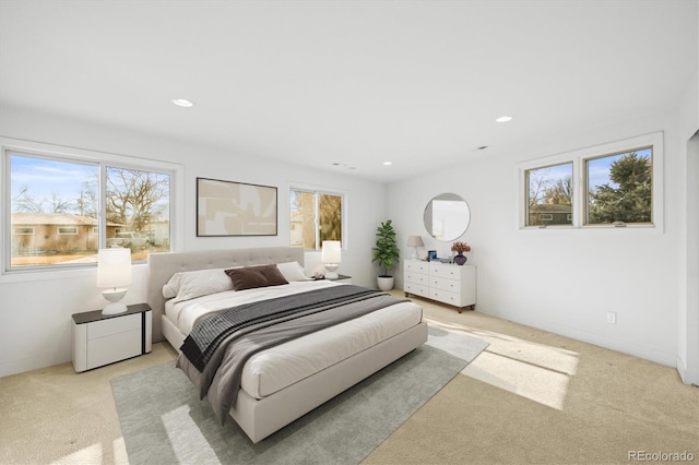 bedroom featuring light carpet and multiple windows