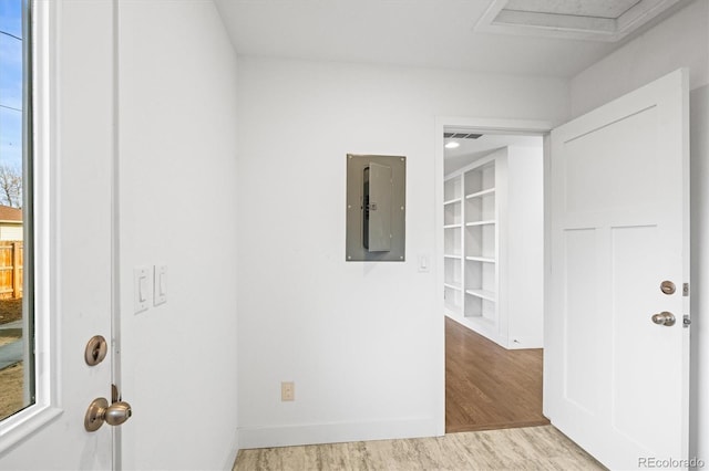 interior space with electric panel, light hardwood / wood-style flooring, and built in shelves