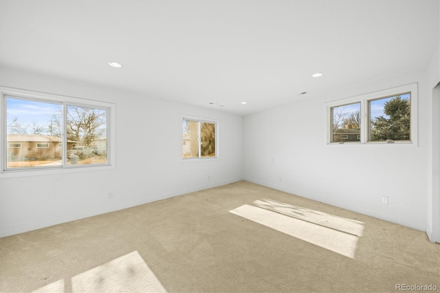 unfurnished room with a healthy amount of sunlight and light carpet