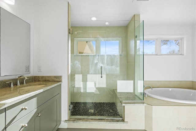 bathroom with a wealth of natural light, vanity, and shower with separate bathtub