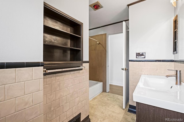 bathroom with vanity, tub / shower combination, built in features, and tile walls