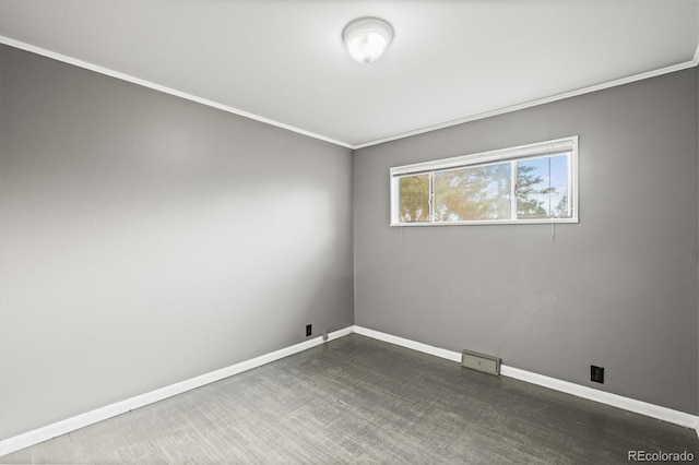 spare room with ornamental molding and dark wood-type flooring