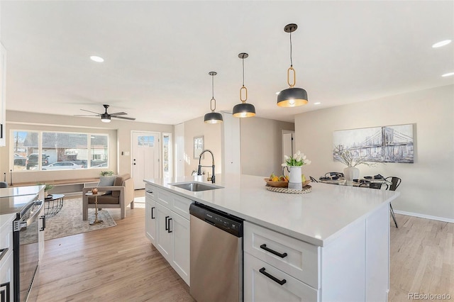 kitchen featuring pendant lighting, white cabinetry, sink, a kitchen island with sink, and stainless steel appliances