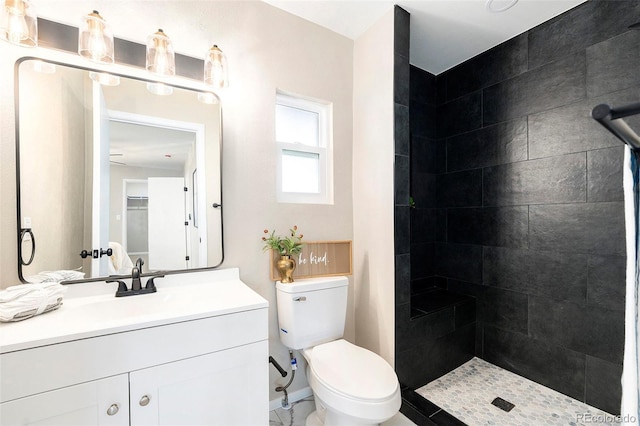 bathroom featuring vanity, toilet, and a tile shower