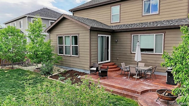 7465 Grady Cir, Castle Rock, CO 80108 - back of property with a patio, an outdoor fire pit, roof with shingles, and entry steps