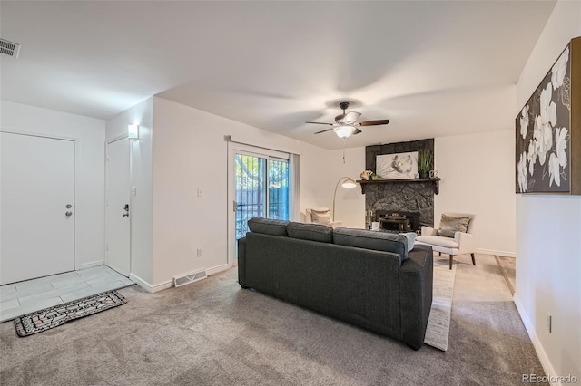 carpeted living room with a fireplace and ceiling fan