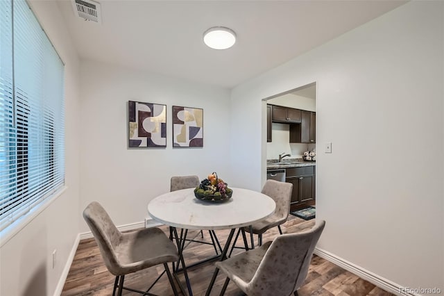 dining room featuring sink, a wealth of natural light, and dark hardwood / wood-style flooring