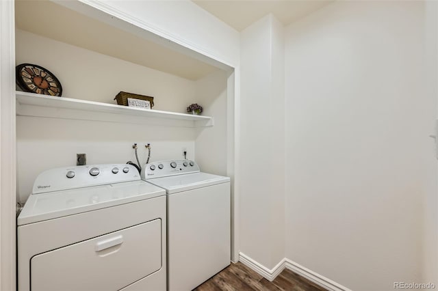 clothes washing area with washing machine and clothes dryer and dark hardwood / wood-style floors