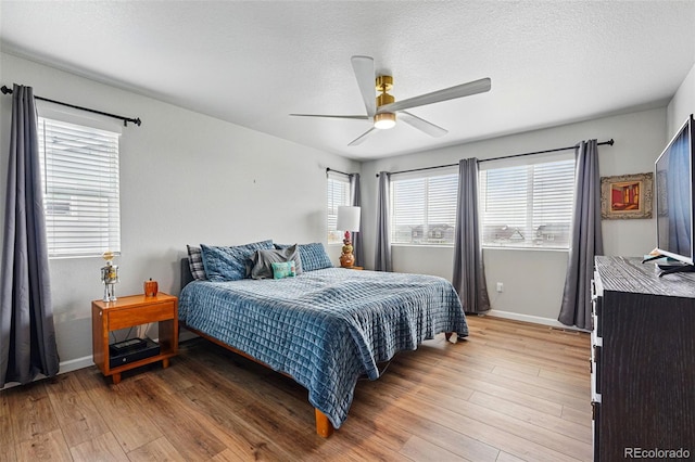 11744 Magnolia Dr, Thornton, CO 80233 - bedroom with light wood-style flooring, baseboards, a ceiling fan, and a textured ceiling