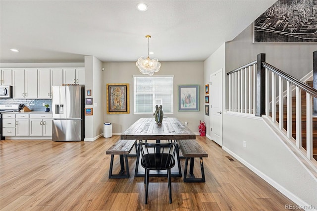 11744 Magnolia Dr, Thornton, CO 80233 - dining space featuring a chandelier, light wood-style floors, baseboards, recessed lighting, and stairs