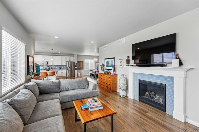 11744 Magnolia Dr, Thornton, CO 80233 - living area with light wood-style floors, recessed lighting, and a glass covered fireplace