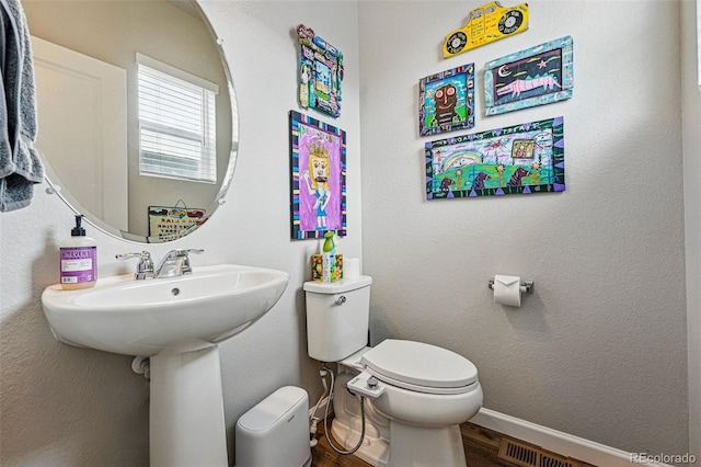 11744 Magnolia Dr, Thornton, CO 80233 - half bathroom with wood finished floors, toilet, and baseboards
