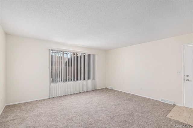 spare room with carpet and a textured ceiling