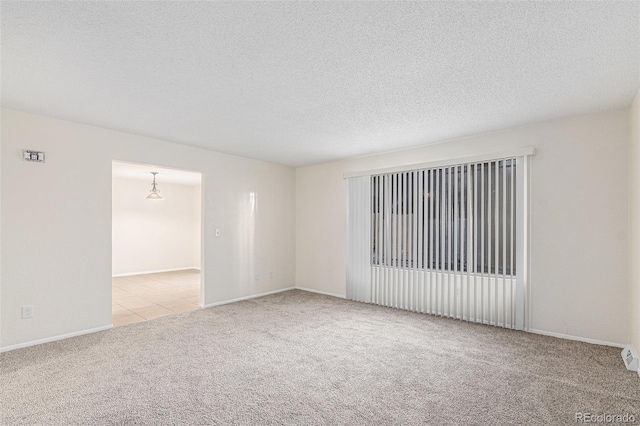 carpeted empty room featuring a textured ceiling