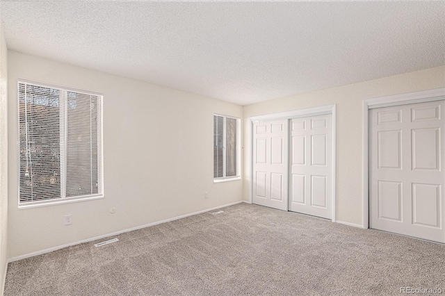 unfurnished bedroom featuring carpet flooring and a textured ceiling