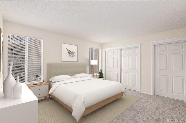 bedroom featuring a textured ceiling, light carpet, and two closets