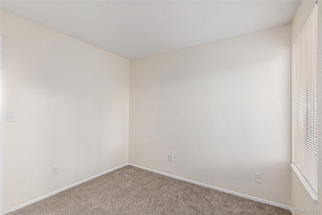 unfurnished room featuring carpet flooring and a textured ceiling