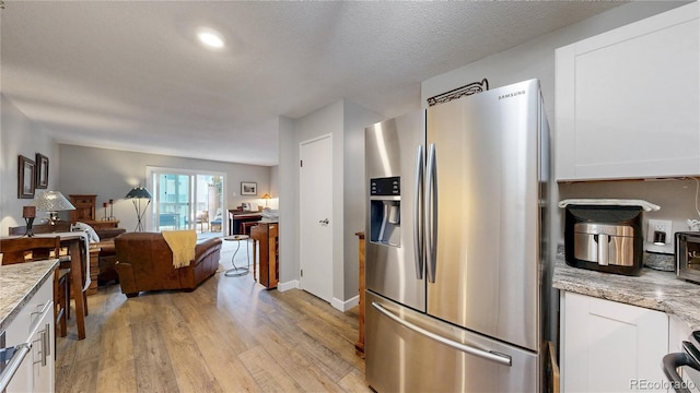 13626 E Bates Ave Unit 302, Aurora, CO 80014 - kitchen featuring stainless steel fridge with ice dispenser, light wood-style floors, white cabinets, and light stone countertops