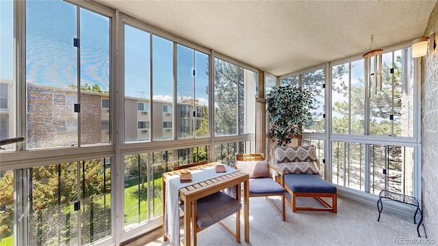 13626 E Bates Ave Unit 302, Aurora, CO 80014 - sunroom with expansive windows, carpet floors, and a textured ceiling