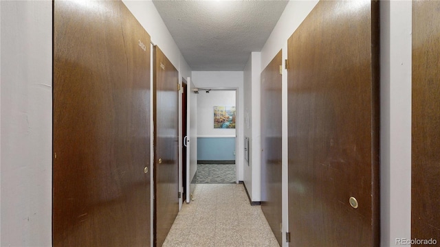 13626 E Bates Ave Unit 302, Aurora, CO 80014 - hallway featuring a textured ceiling and baseboards