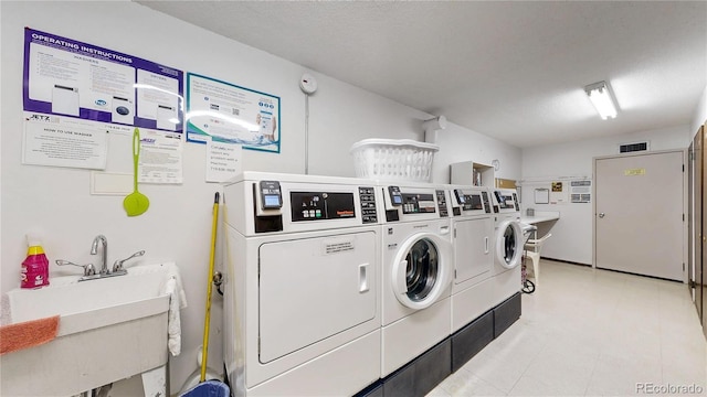13626 E Bates Ave Unit 302, Aurora, CO 80014 - community laundry featuring washing machine and dryer and a textured ceiling