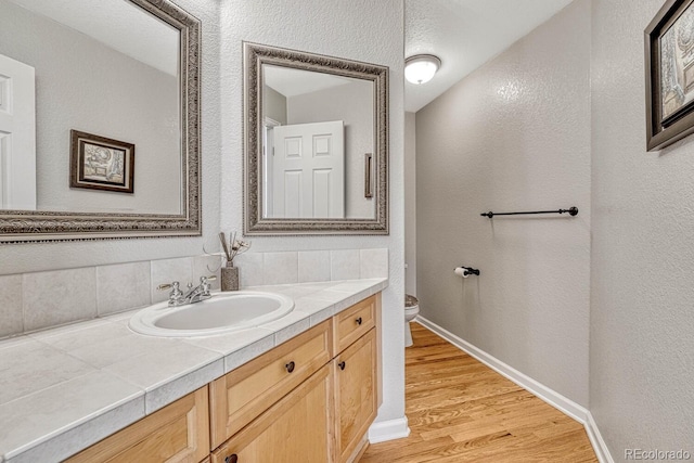 bathroom featuring vanity, toilet, and hardwood / wood-style flooring