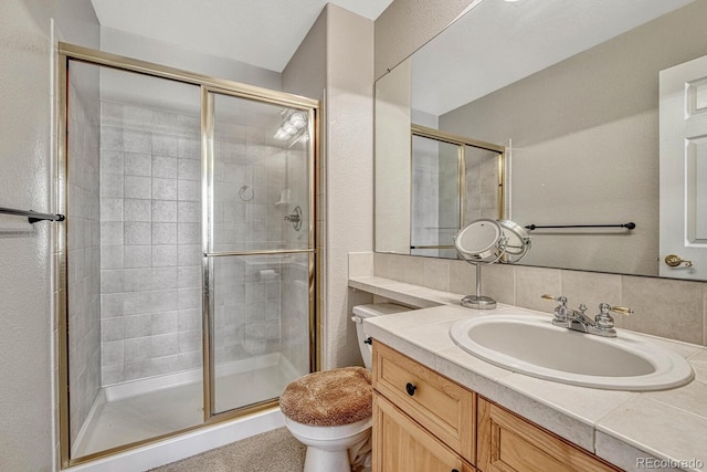 bathroom featuring backsplash, vanity, toilet, and walk in shower