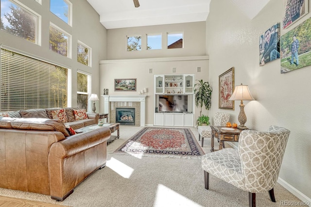 carpeted living room with a high ceiling and a fireplace