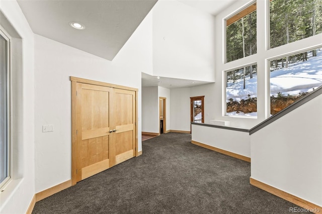 10508 Christopher Dr, Conifer, CO 80433 - empty room featuring dark colored carpet, recessed lighting, and a towering ceiling