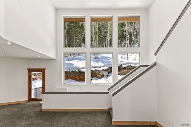 10508 Christopher Dr, Conifer, CO 80433 - unfurnished living room with dark colored carpet, healthy amount of natural light, and a towering ceiling