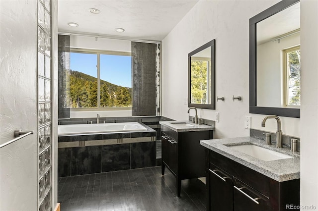 10508 Christopher Dr, Conifer, CO 80433 - bathroom with two vanities, hardwood / wood-style flooring, and a bath