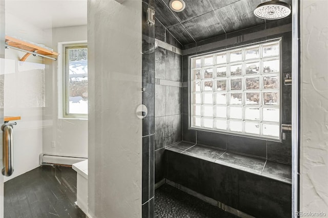 10508 Christopher Dr, Conifer, CO 80433 - bathroom with a baseboard radiator, a tile shower, and wood finished floors