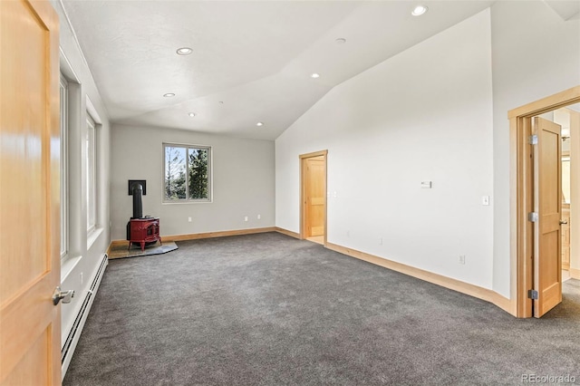 10508 Christopher Dr, Conifer, CO 80433 - empty room with a baseboard radiator, carpet, a wood stove, vaulted ceiling, and recessed lighting