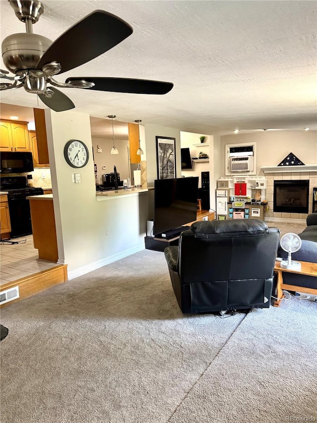 6616 S Lincoln St, Centennial, CO 80121 - living room featuring light colored carpet, a ceiling fan, a textured ceiling, an AC wall unit, and a tile fireplace