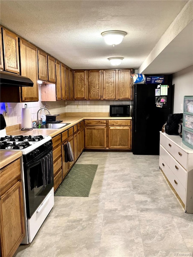 6616 S Lincoln St, Centennial, CO 80121 - kitchen with black appliances, range hood, brown cabinetry, light countertops, and a textured ceiling