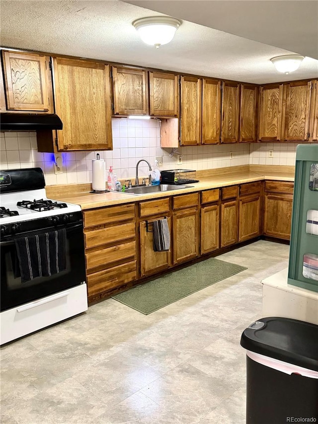 6616 S Lincoln St, Centennial, CO 80121 - kitchen featuring gas range, brown cabinets, tasteful backsplash, light countertops, and a textured ceiling