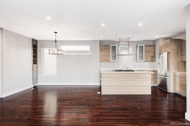 kitchen featuring a center island, dark hardwood / wood-style flooring, high end refrigerator, decorative light fixtures, and extractor fan